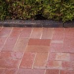 Old Red Pavers In Basketweave Pattern Next To Garden